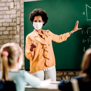 Teacher wearing a mask and instructing students