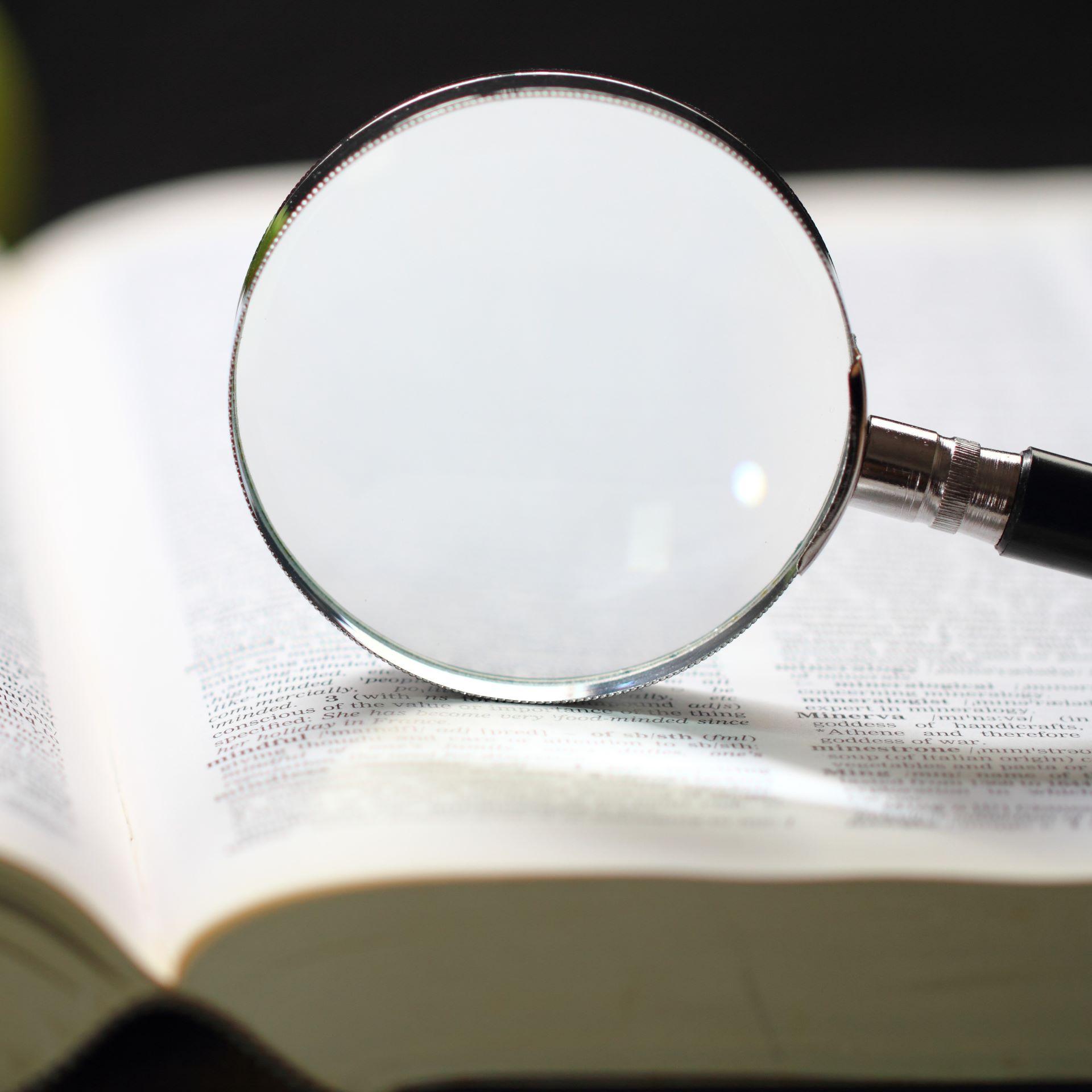 magnifying glass on dictionary