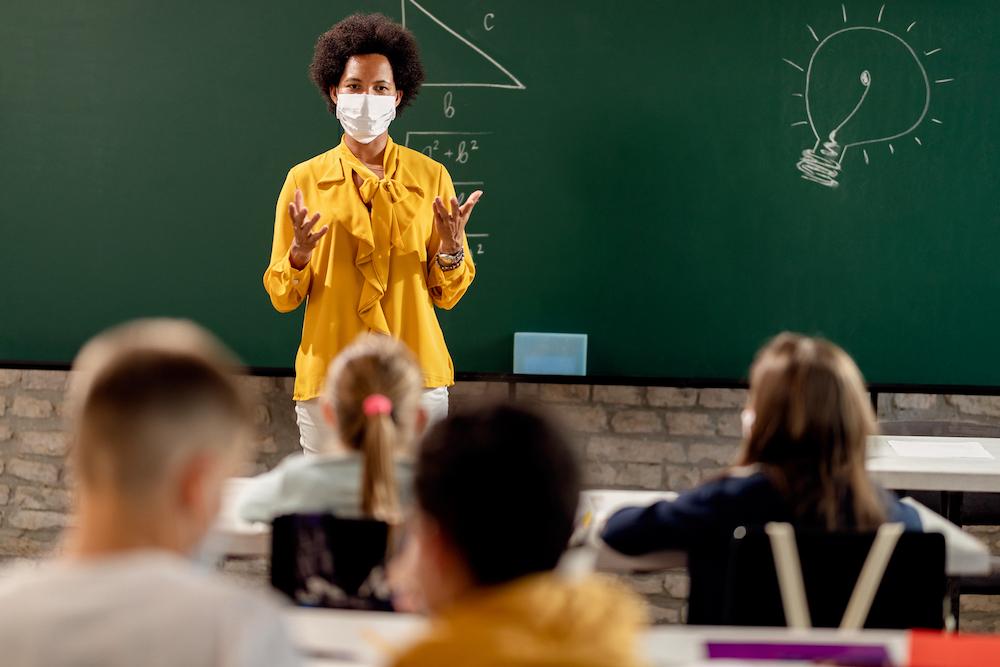 Teach in mask in front of classrom