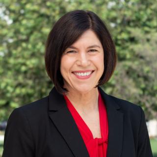 Headshot of Heidi Semann wearing a red blouse and black blazer.